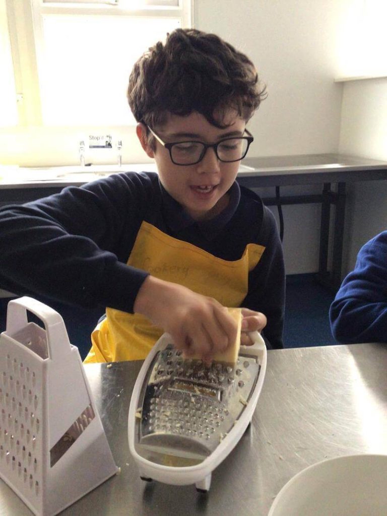 student grating cheese